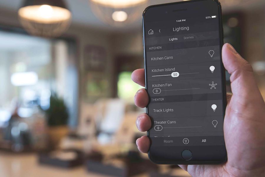 Person holding iphone with Control4 interface on it