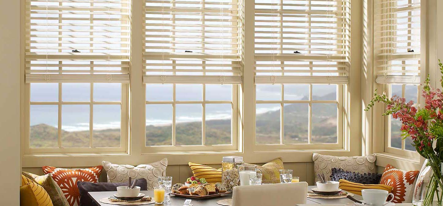 Bright breakfast nook with white blinds overlooking ocean and hillside