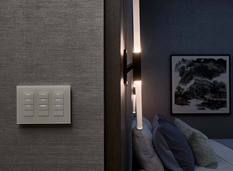Wall keypad on textured surface next to modern bedside lighting