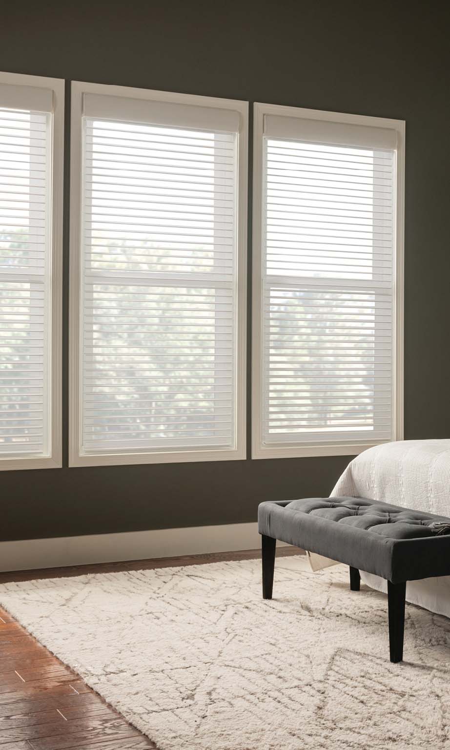 Bedroom windows with white blinds letting in filtered daylight