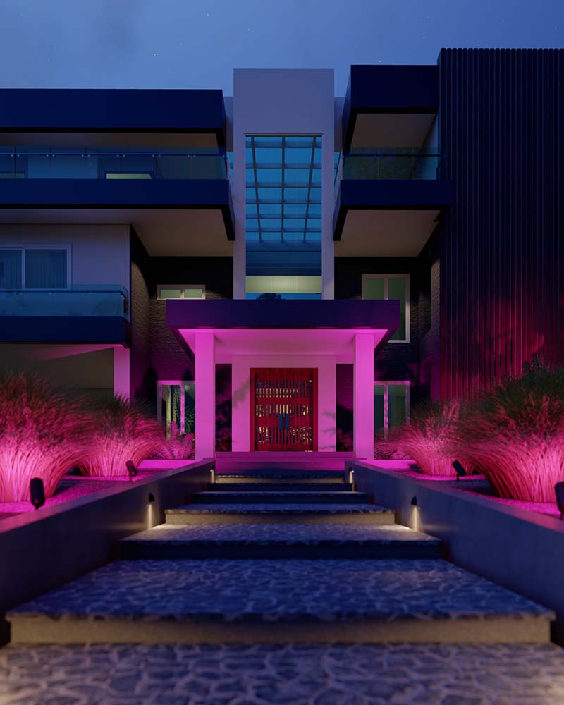 House exterior lit with vibrant pink landscape lighting at night