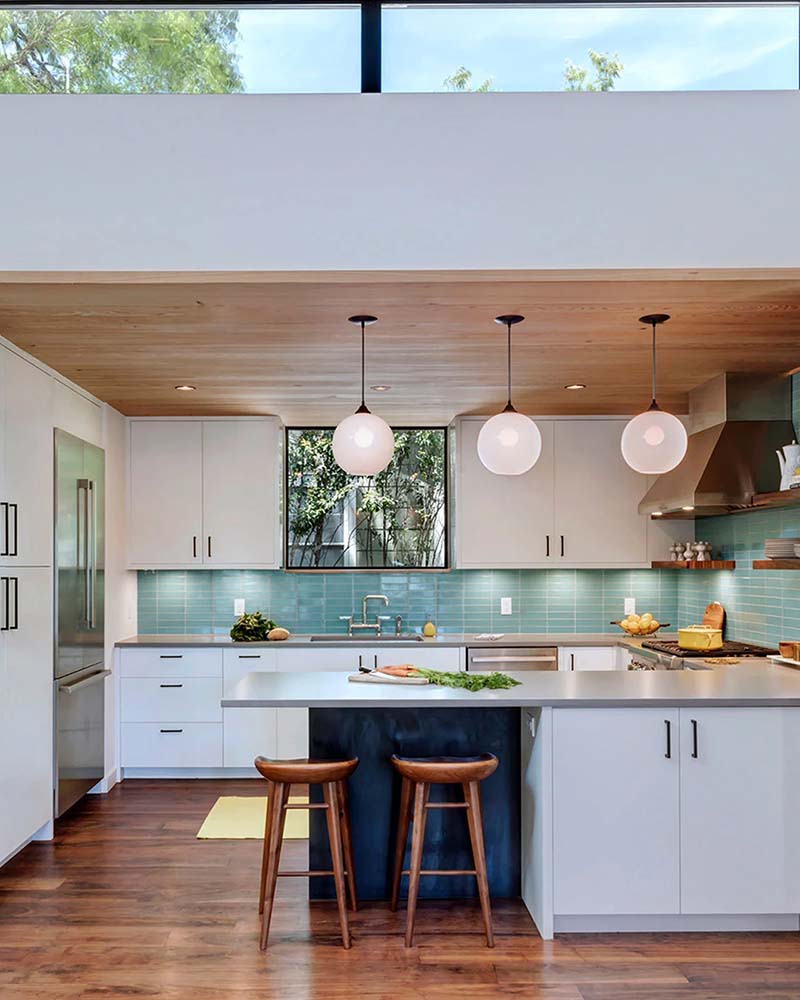 Bright kitchen with teal backsplash and globe pendant lighting