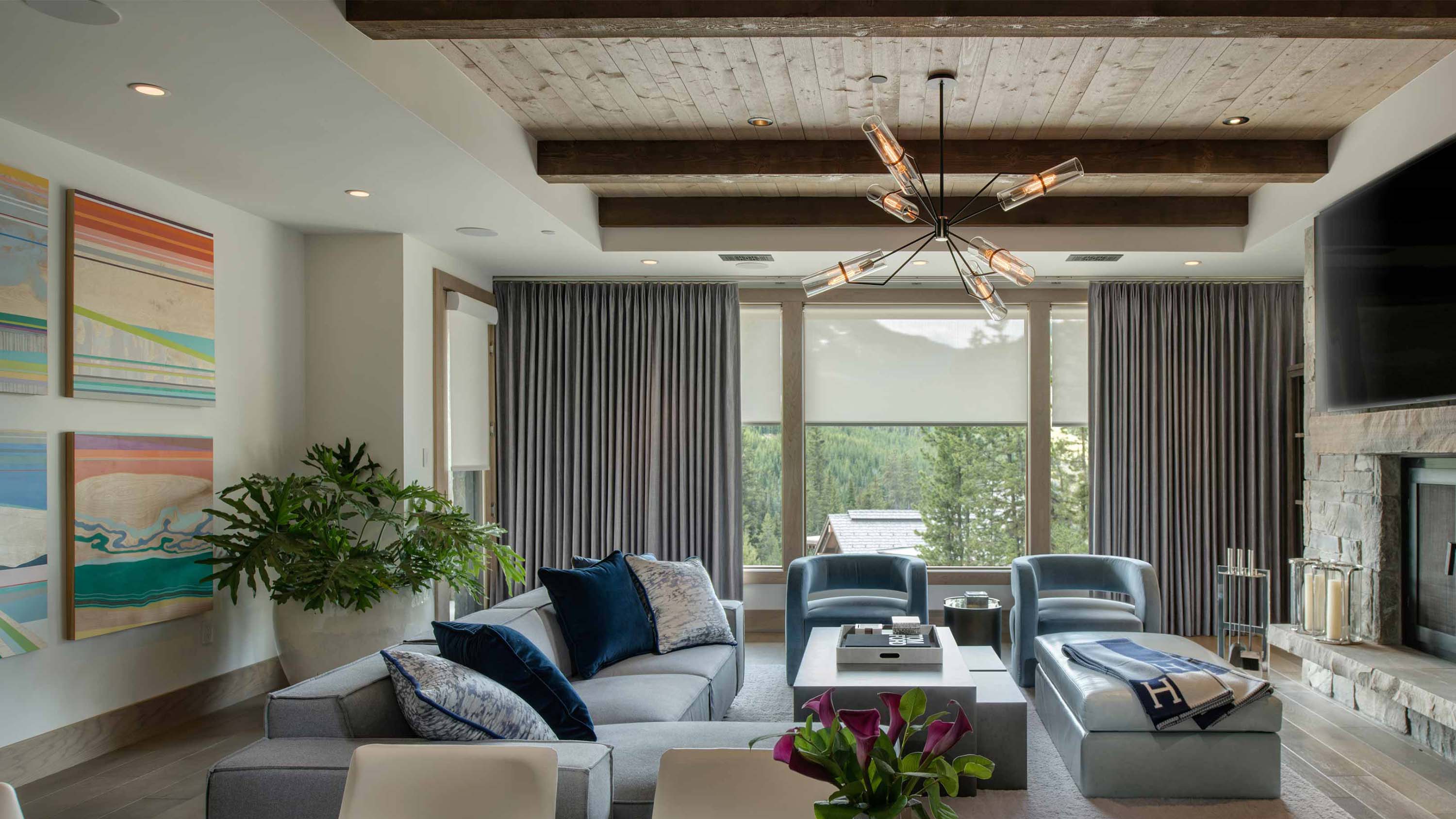 Living room with layered drapery and roller shades framing large windows