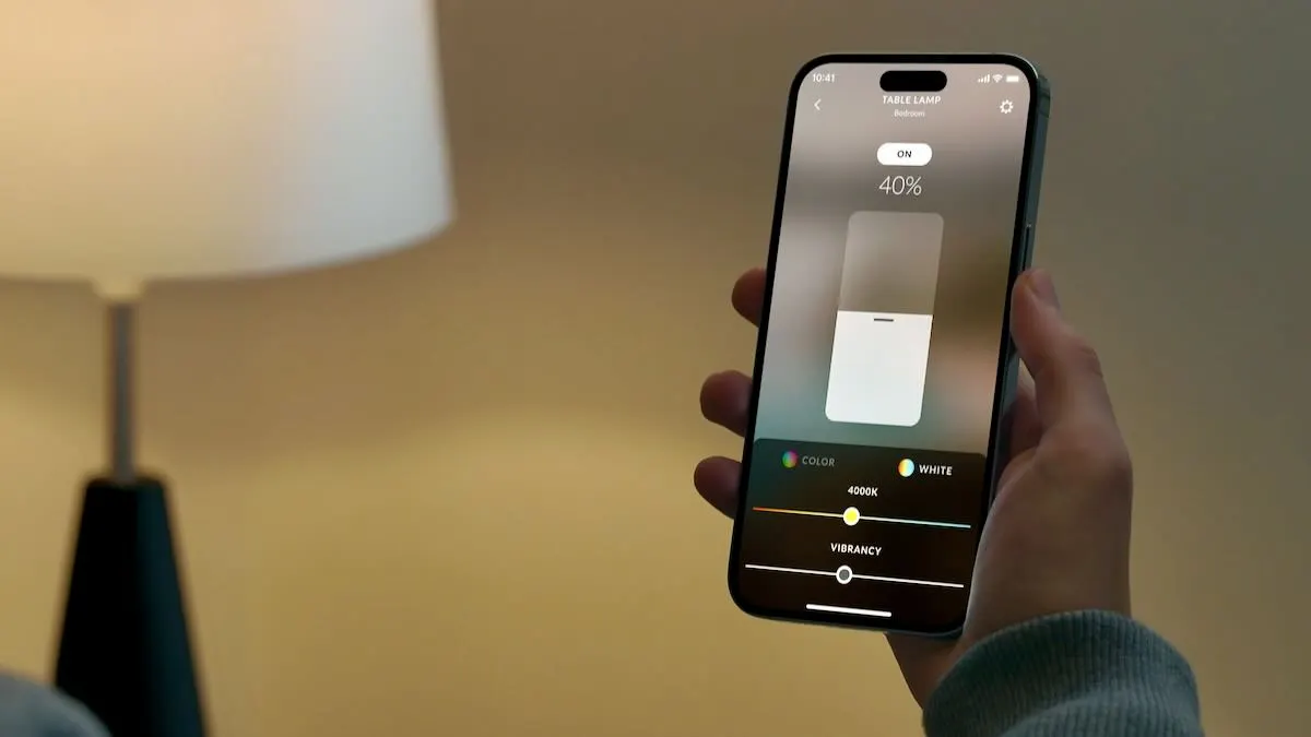 homeowner adjusting smart lighting from a phone app using a home control system