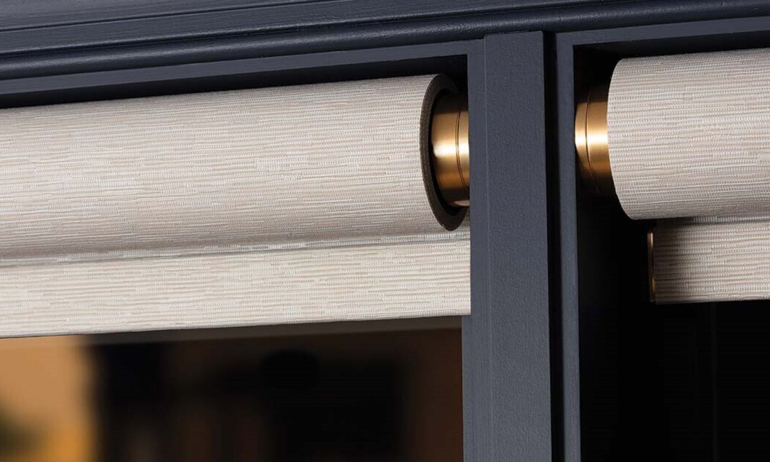 Close up of textured roller shades with brass hardware