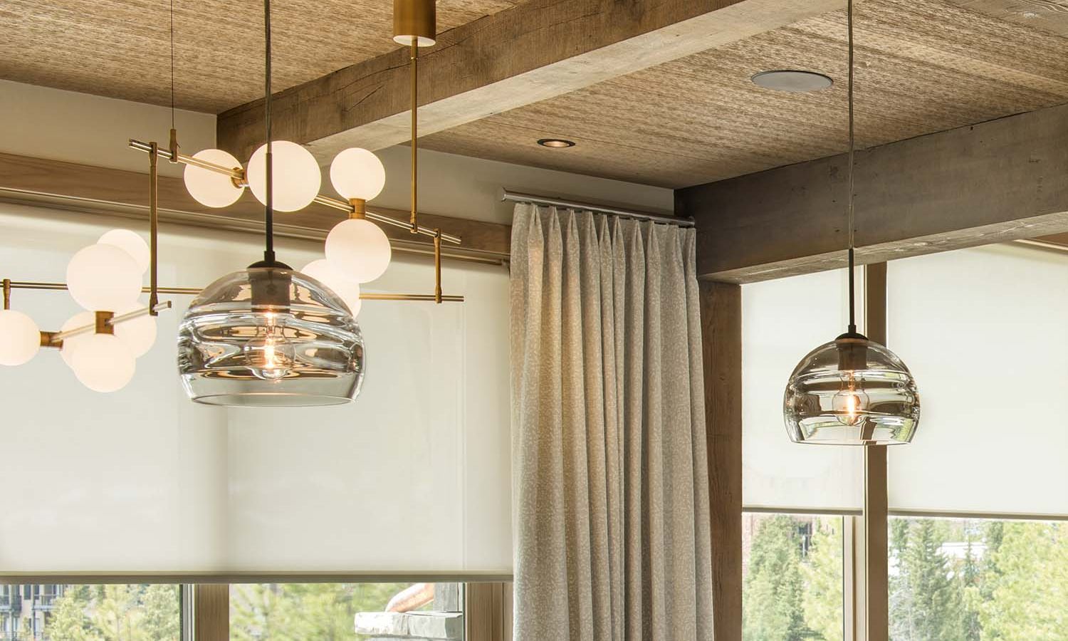 Pendant lights and window shades in a room with wood ceiling beams