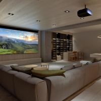A casual home theater with a large screen, Sony projector, wine bar, pool table, and sectional.